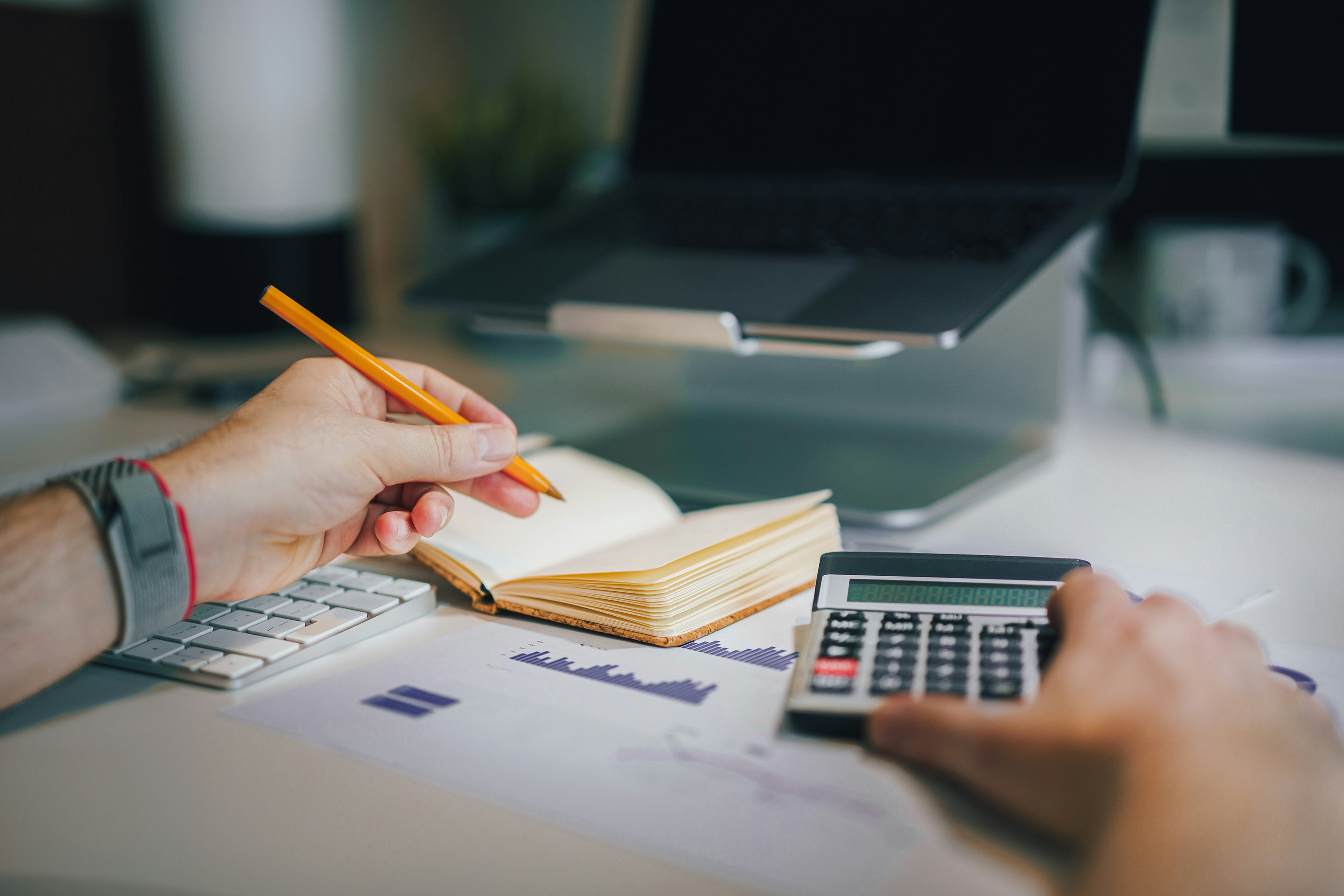 Accounting work in progress — calculator, ledger and reports on a desk